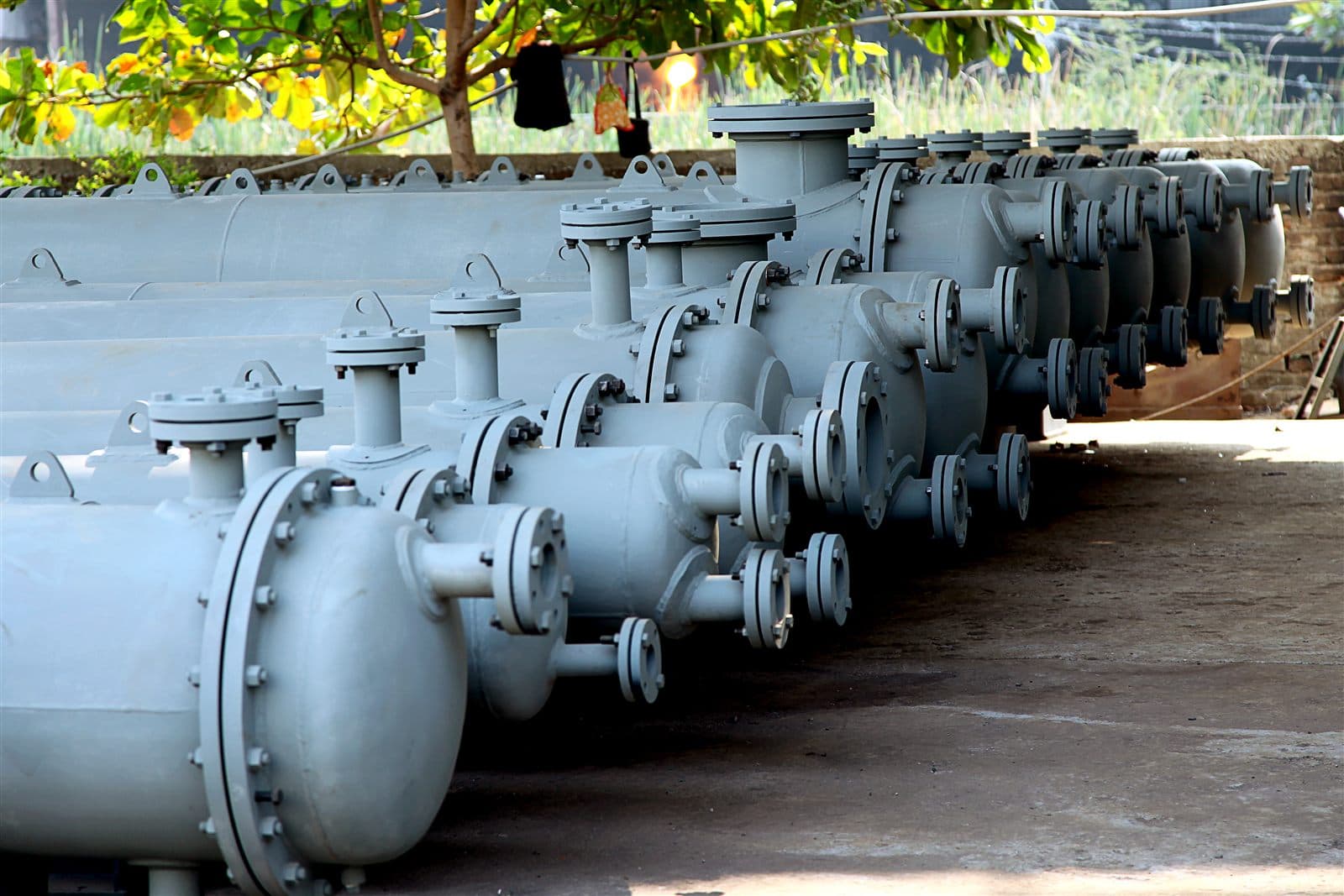Row of completed shell and tube heat exchangers staged for dispatch